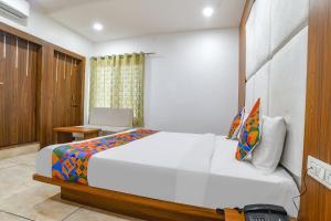 een slaapkamer met een groot bed en een bureau bij FabHotel Right Choice in Indore