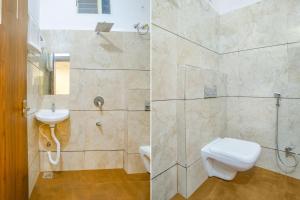 een badkamer met een toilet, een wastafel en een douche bij FabHotel Right Choice in Indore