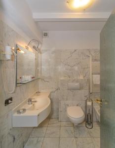 a white bathroom with a sink and a toilet at L'incanto Di Boccadarno in Marina di Pisa