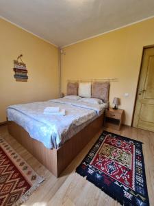 a bedroom with a large bed and a rug at CASA VISTISOARA in Viştea de Sus