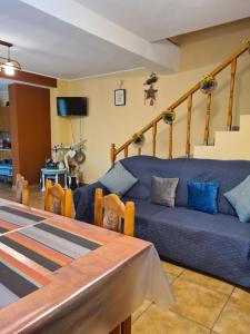 a living room with a blue couch and stairs at CASA VISTISOARA in Viştea de Sus