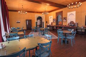 a restaurant with wooden tables and blue chairs at Knyazli Family Suites & Rooms in Kiçik Qaramurad