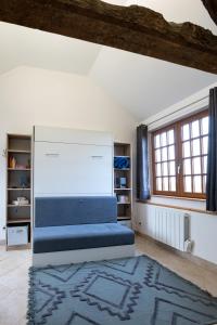 a bedroom with a bed and a rug at La Bouillerie du Manoir des Bréholles in Goustranville