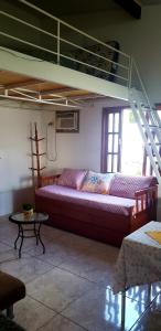 uma sala de estar com um sofá debaixo de um beliche em Casa da Dinda à 650m da praia de Itaúna em Saquarema