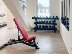 een fitnessruimte met een rode stoel in een kamer bij DORMERO Hotel Hersbruck in Hersbruck