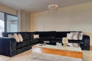a living room with a black couch and a coffee table at Villa 58, a Home in Madeira in Santa Cruz