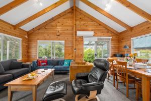 a living room filled with furniture and a wooden ceiling at Piece of Paradise - Turangi Holiday Home in Turangi