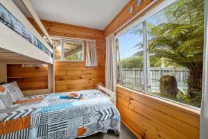 a bedroom with a bed and a large window at Piece of Paradise - Turangi Holiday Home in Turangi