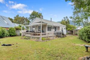 a white house with a porch and a yard at Piece of Paradise - Turangi Holiday Home in Turangi