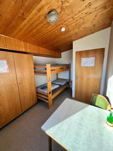 Cette chambre comprend 2 lits superposés et une table. dans l'établissement Camping am Bootshaus, à Beverungen