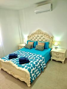 a bedroom with a blue and white bed with two pillows at APARTAMENTOS ELEMAR free luggage storage in Málaga