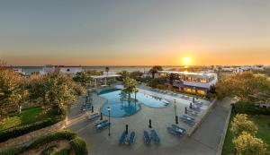 uma vista superior de uma piscina com cadeiras e do oceano em Skiros Palace Hotel em Skiros