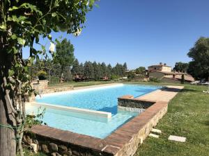 einen Pool in einem Garten mit einer Haltewand in der Unterkunft Appartamento Pino in Trequanda