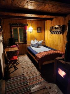 a bedroom with a bed in a wooden room at Cabana Farmec Ciubăr - Dézsabáj Kulcsosház in Sovata