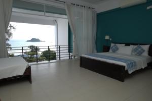 a bedroom with a bed and a view of the ocean at Dazzle Bay by Twenty Two in Weligama