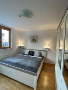 1 dormitorio con 1 cama grande con 2 luces. en Apartma Pohorje, en Hočko Pohorje