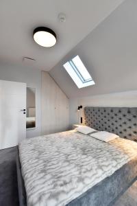 a bedroom with a large bed and a skylight at RIVER'S TOUCH Apartament Grand z widokiem na Odrę in Szczecin