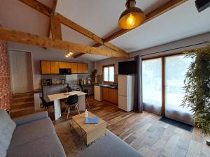 uma sala de estar com um sofá e uma cozinha em L'Annexe- guest house avec piscine studio avec coin chambre em Rosny-sur-Seine