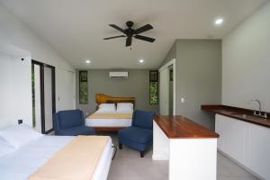 1 dormitorio con 2 camas, escritorio y lavamanos en Costa Rican Jungle Experience, en Tinamaste