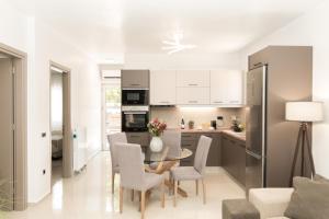 Una cocina y un comedor con mesa y sillas. en Al Santo Apartments, en Zakynthos