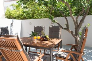 una mesa y sillas con un bol de fruta. en Al Santo Apartments en Zakynthos