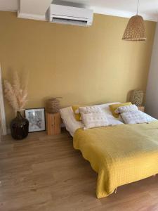 a bedroom with a bed with a yellow blanket at Villa Junna in Fréjus