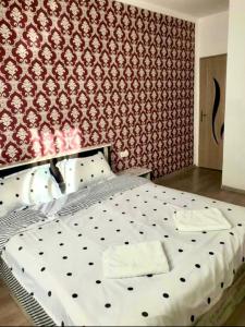 uma cama num quarto com uma parede vermelha em Apartament Mara em Alba Iulia