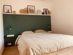 een slaapkamer met een groen hoofdeinde en een bed bij Maison en plein centre avec terrasse et jardin in Vielsalm