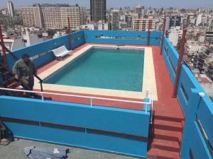um homem a limpar uma piscina no topo de um edifício em Recoleta Mediterráneo em Buenos Aires