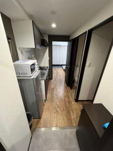 a small kitchen with a stove and a microwave at shizuka1 501 in Osaka