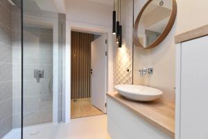 a bathroom with a sink and a mirror at RIVER'S TOUCH Apartament Grand z widokiem na Odrę in Szczecin