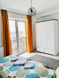 - une chambre avec un lit et une grande fenêtre dans l'établissement Apartament Mara Centru, à Alba Iulia