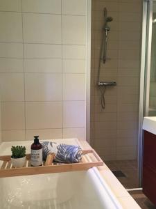 a bathroom with a tub and a shower and a sink at Moonvalley Lodge - stort & koselig hus - Måndalen in Sæbø