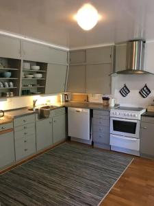 een keuken met witte kasten en een witte kookplaat bij Moonvalley Lodge - stort & koselig hus - Måndalen in Sæbø