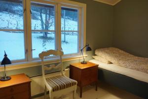 a bedroom with a bed and a window and a chair at Moonvalley Lodge - stort & koselig hus - Måndalen in Sæbø