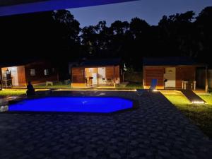 ein blauer Pool in einem Garten in der Nacht in der Unterkunft Major Holidays in Garnier