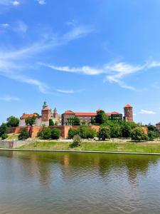 a view of a castle from the river at Hotel Poleski in Kraków