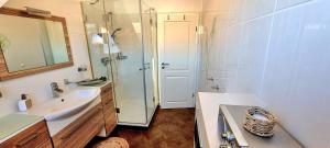 a bathroom with a sink and a glass shower at Lüneburg-Melbeck, 105 qm mit Fernsicht, ruhige Sackgasse, Fussbodenheizung in Melbeck +26 photos