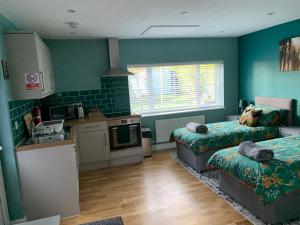 eine Küche mit 2 Betten und einem Waschbecken in einem Zimmer in der Unterkunft Walnut Lodge, Timberland in Martin