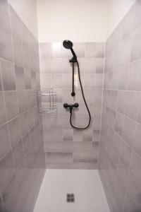 a shower with a shower head in a tiled bathroom at Wellnes apartmán Leqwell in Uherský Brod