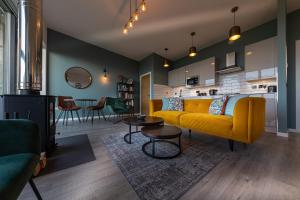 a living room with a yellow couch and a table at Silverwood Waternish in Portree