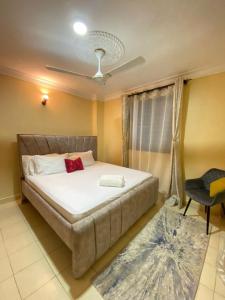 a bedroom with a large bed and a chair at Lovely and homely 2 bedroom Serviced Apartment in Kilifi