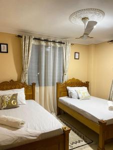 a bedroom with two beds and a window at Lovely and homely 2 bedroom Serviced Apartment in Kilifi