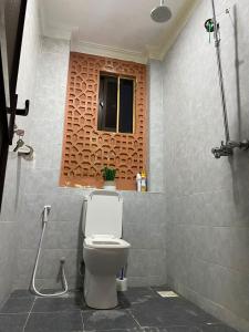 a bathroom with a toilet and a window at Lovely and homely 2 bedroom Serviced Apartment in Kilifi
