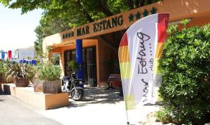 a sign in front of a building with a umbrella at Mobilhome NEUF Mar estang Accès Plage in Canet-en-Roussillon