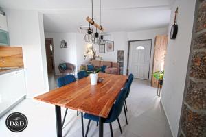 a kitchen and dining room with a wooden table and blue chairs at Apartment D&D in Opatija