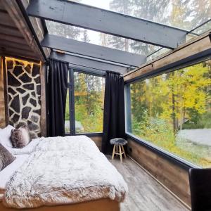 a bedroom with a bed and a large window at Himosranta Suites in Jämsä