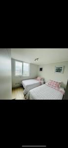 sypialnia z 2 łóżkami i oknem w obiekcie Hermoso departamento Viña del Mar w mieście Viña del Mar