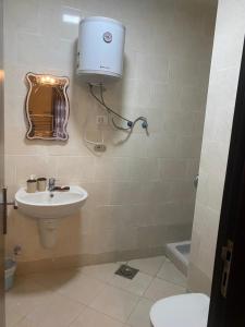 a bathroom with a toilet and a sink and a light at 2 Bedroom Ground floor Chalet with Terrace - Porto Sokhna - Families Only in Ain Sokhna