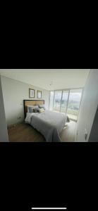 sypialnia z dużym łóżkiem i dużym oknem w obiekcie Hermoso departamento Viña del Mar w mieście Viña del Mar